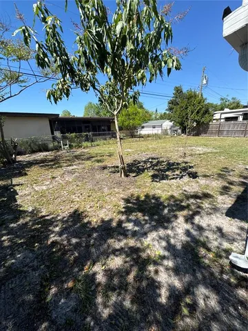 a view of a yard with wooden fence