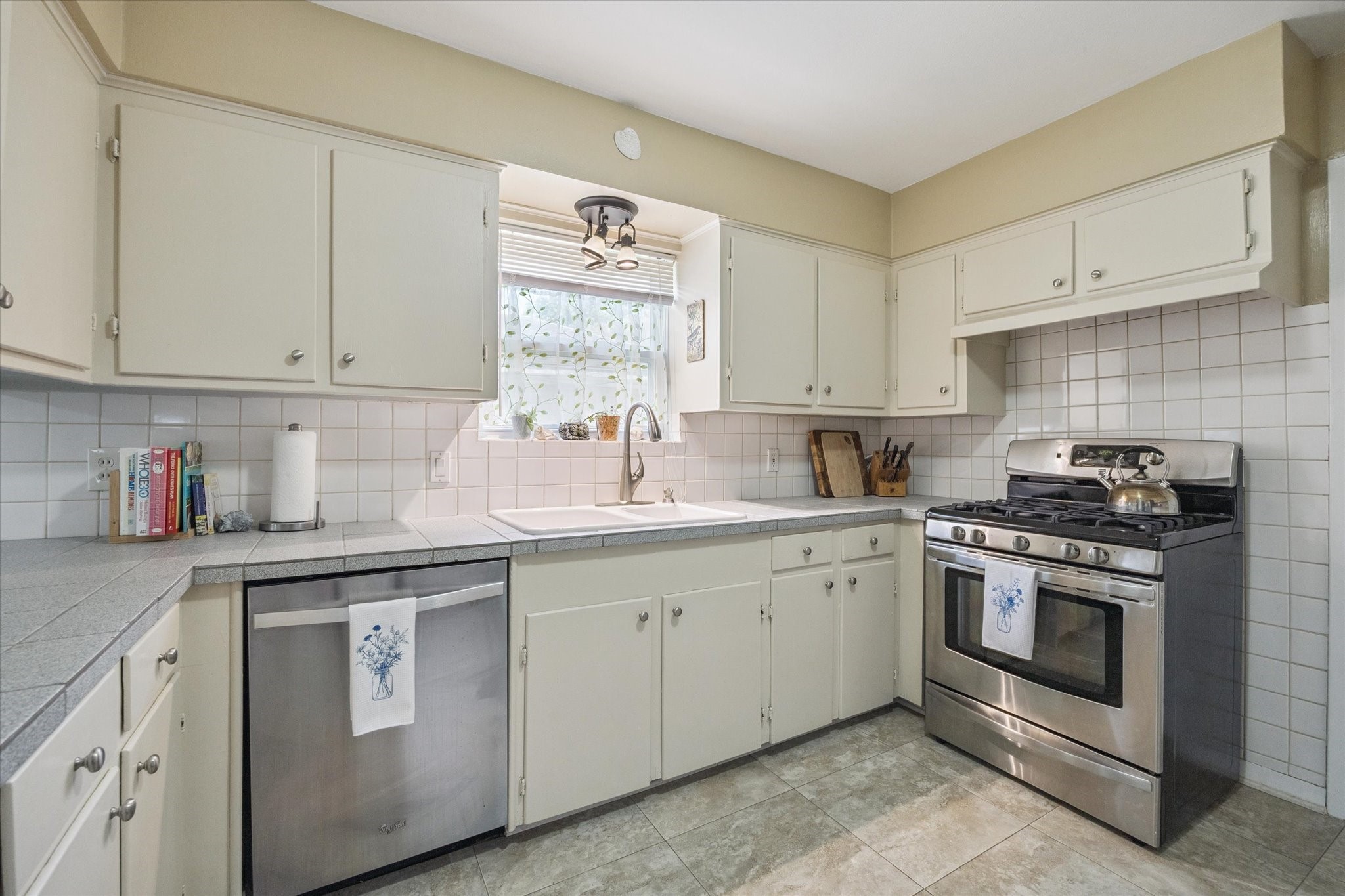 5114 Kinglet Street Houston, TX 77035 - Photo 11 of 20 a kitchen with white cabinets sink and stainless steel appliances