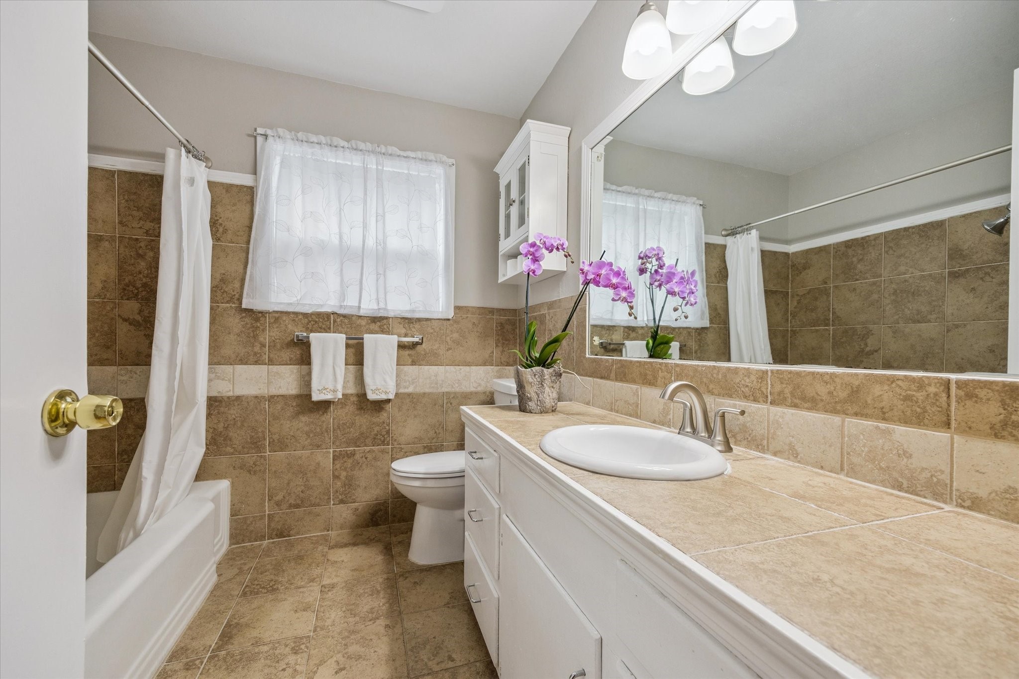 5114 Kinglet Street Houston, TX 77035 - Photo 17 of 20 a bathroom with a sink a mirror and a bathtub