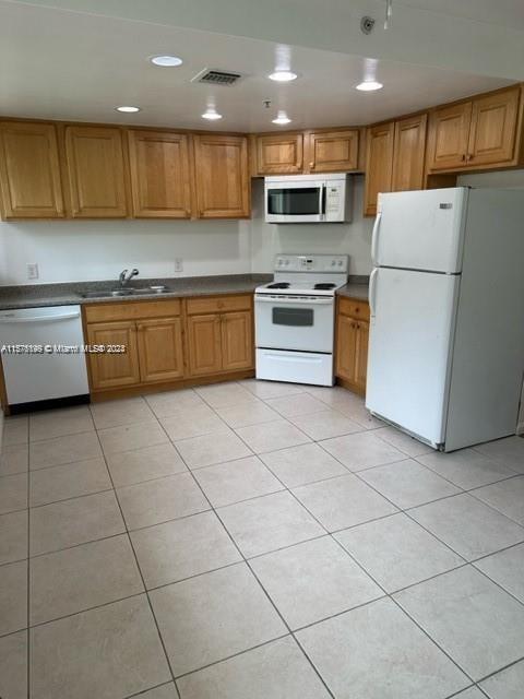a kitchen with a sink a stove top oven and white stainless steel appliances