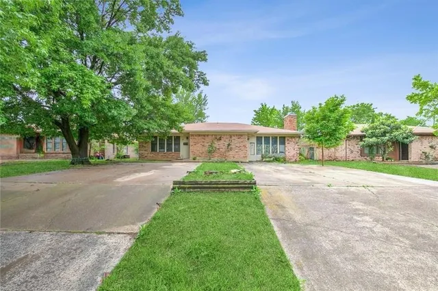 a front view of a house with a yard and potted plants