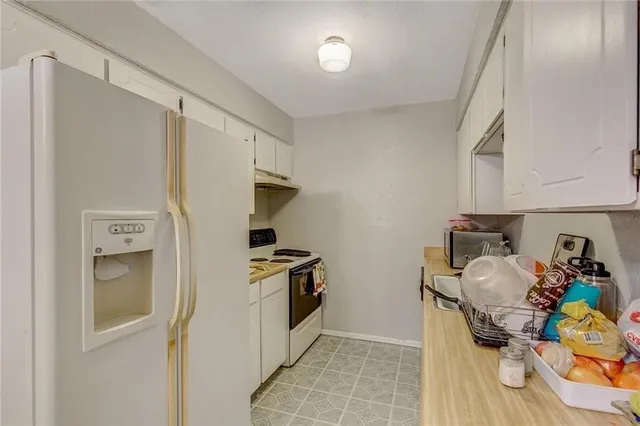 a view of a kitchen with fridge and workspace