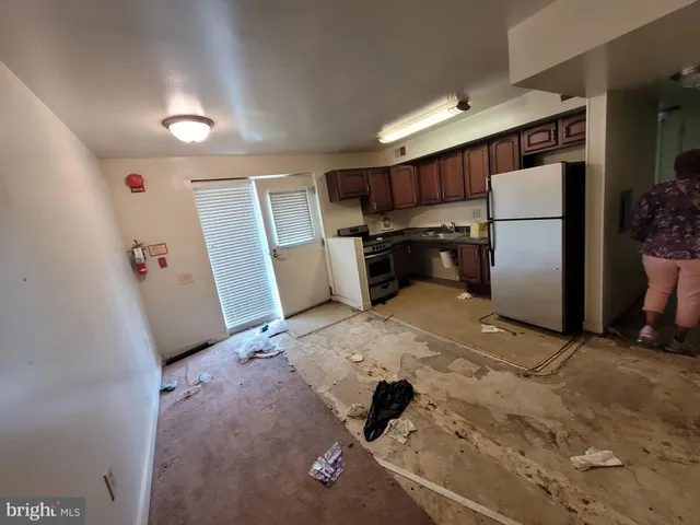 a kitchen with a refrigerator sink stove and cabinets
