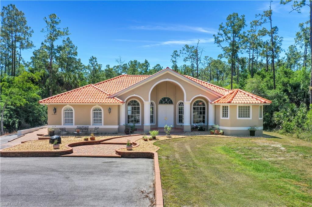 4364 6th Avenue Southeast Naples, FL 34117 - Photo 1 of 35 a front view of a house with yard and trees in the background