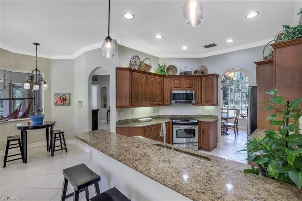 4364 6th Avenue Southeast Naples, FL 34117 - Photo 11 of 35 a large kitchen with cabinets table and chairs