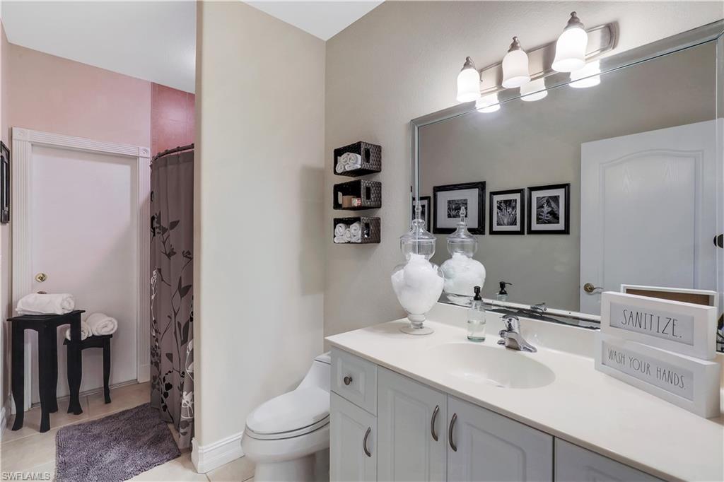 4364 6th Avenue Southeast Naples, FL 34117 - Photo 19 of 35 a bathroom with a sink a toilet and a mirror