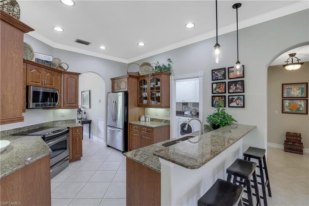 4364 6th Avenue Southeast Naples, FL 34117 - Photo 9 of 35 a kitchen with stainless steel appliances granite countertop a stove and a sink