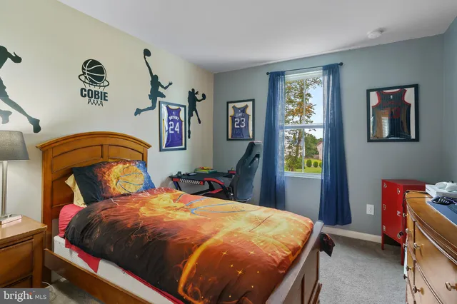 a bedroom with a bed and dresser with mirror