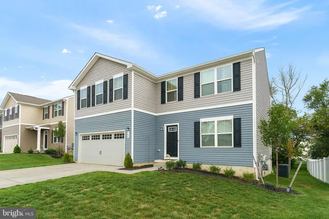 a front view of a house with a yard and trees