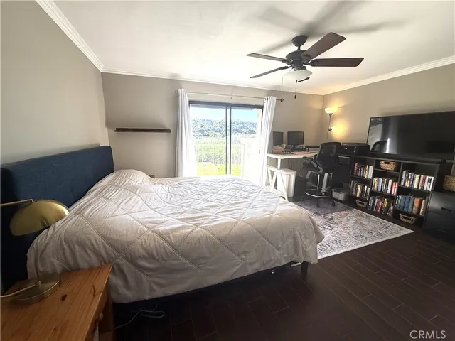 a bedroom with a bed and a flat tv screen on dresser