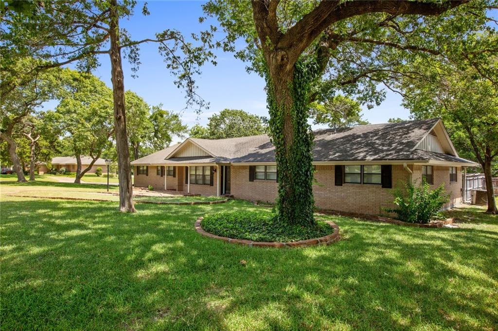 a view of a house with a yard and tree s