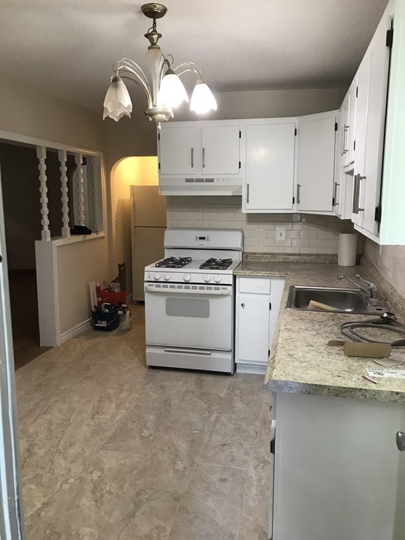 a kitchen with a stove a sink and cabinets