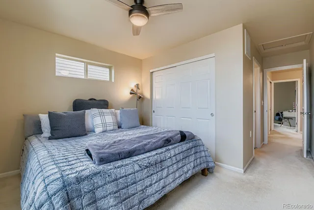 a bedroom with a large bed and ceiling fan