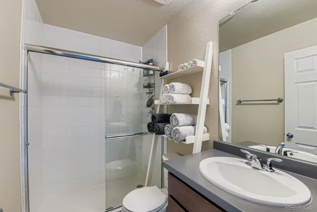 a bathroom with a sink toilet a mirror and shower