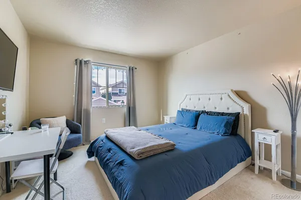 a bedroom with a bed a table and chair