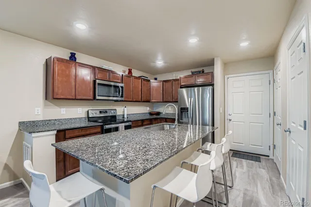 a kitchen with stainless steel appliances granite countertop a refrigerator stove microwave and sink
