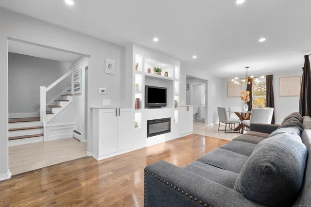 a living room with furniture a fireplace and a flat screen tv