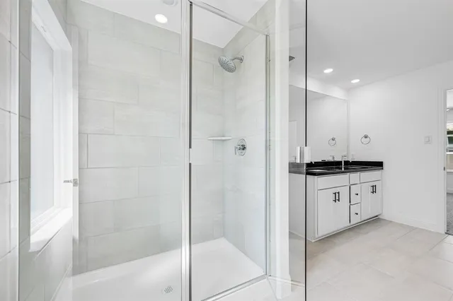 a bathroom with a granite countertop sink a shower and a mirror