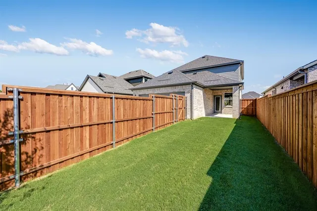 a view of a backyard with wooden fence