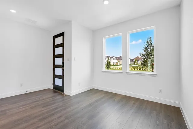 an empty room with wooden floor and window