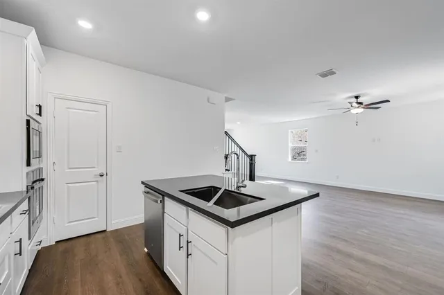 a kitchen that has a sink a stove and cabinets