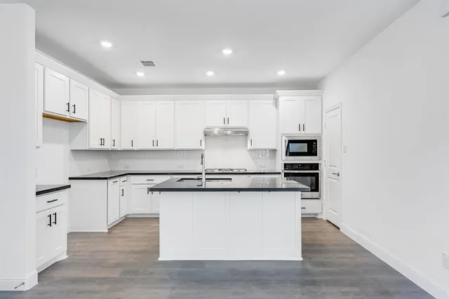 a kitchen with stainless steel appliances granite countertop a stove and a sink