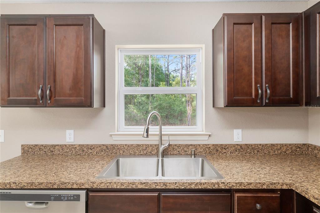 2 Hemlock Loop Drive Ocala, FL 34472 - Photo 12 of 28 a kitchen with granite countertop cabinets sink and window