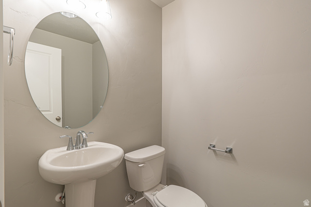 2257 South 1090 West, Unit 74 Nibley, UT 84321 - Photo 7 of 40 Pedestal sink with chrome faucet, oval mirror, and overhead vanity lighting