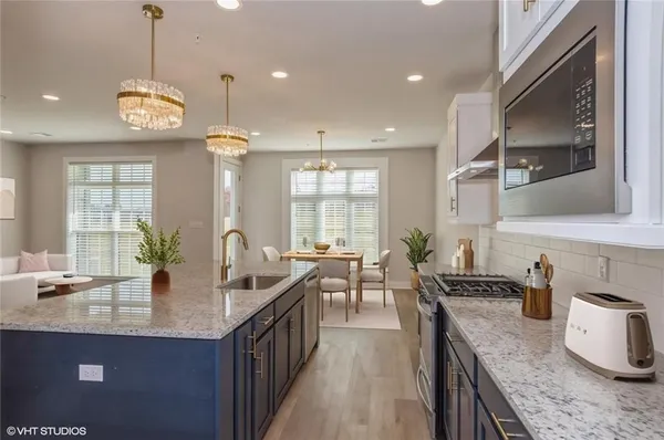 a kitchen with granite countertop a sink a stove and cabinets
