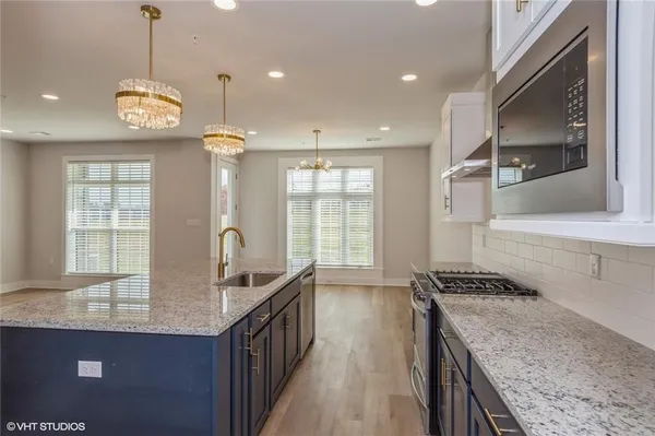 a kitchen with granite countertop stove a sink and a refrigerator