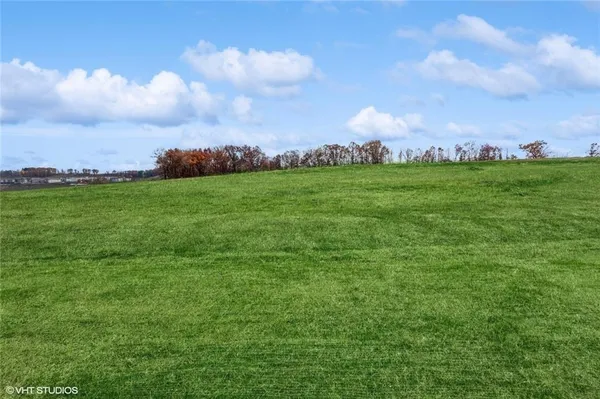 a view of a golf course with huge green field and houses