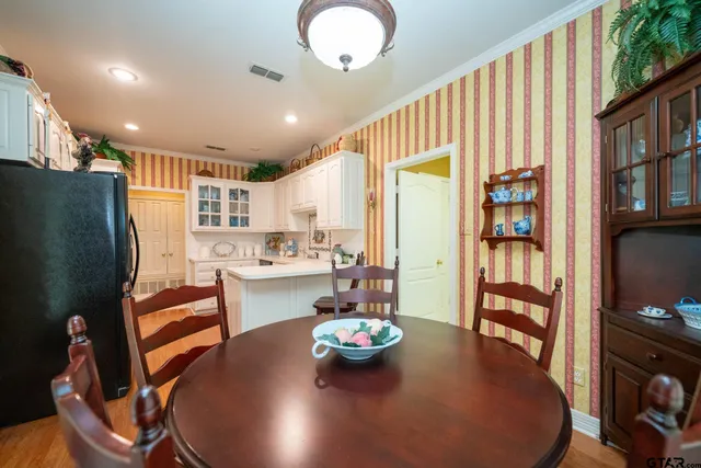a kitchen with stainless steel appliances wooden floor dining table and chairs