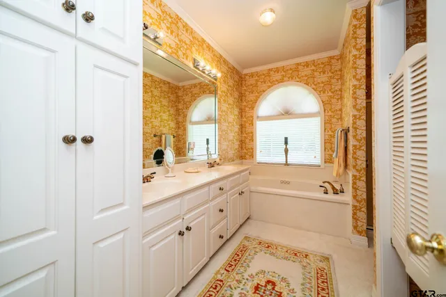 a spacious bathroom with a double vanity sink a mirror and a bathtub