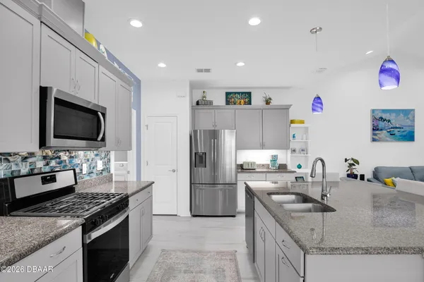 a kitchen that has a sink and a stove in it