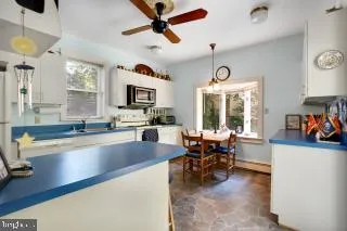 a kitchen with stainless steel appliances granite countertop sink stove and white cabinets with wooden floor