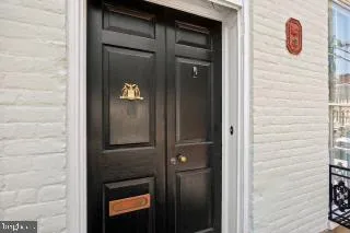 a hallway with dining room wooden floor and chandelier