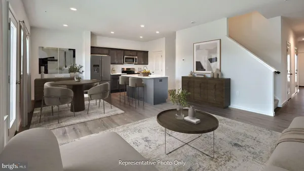 a living room with furniture a rug and kitchen view