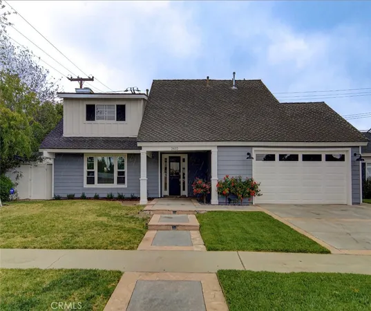 a front view of a house with a yard and potted plants