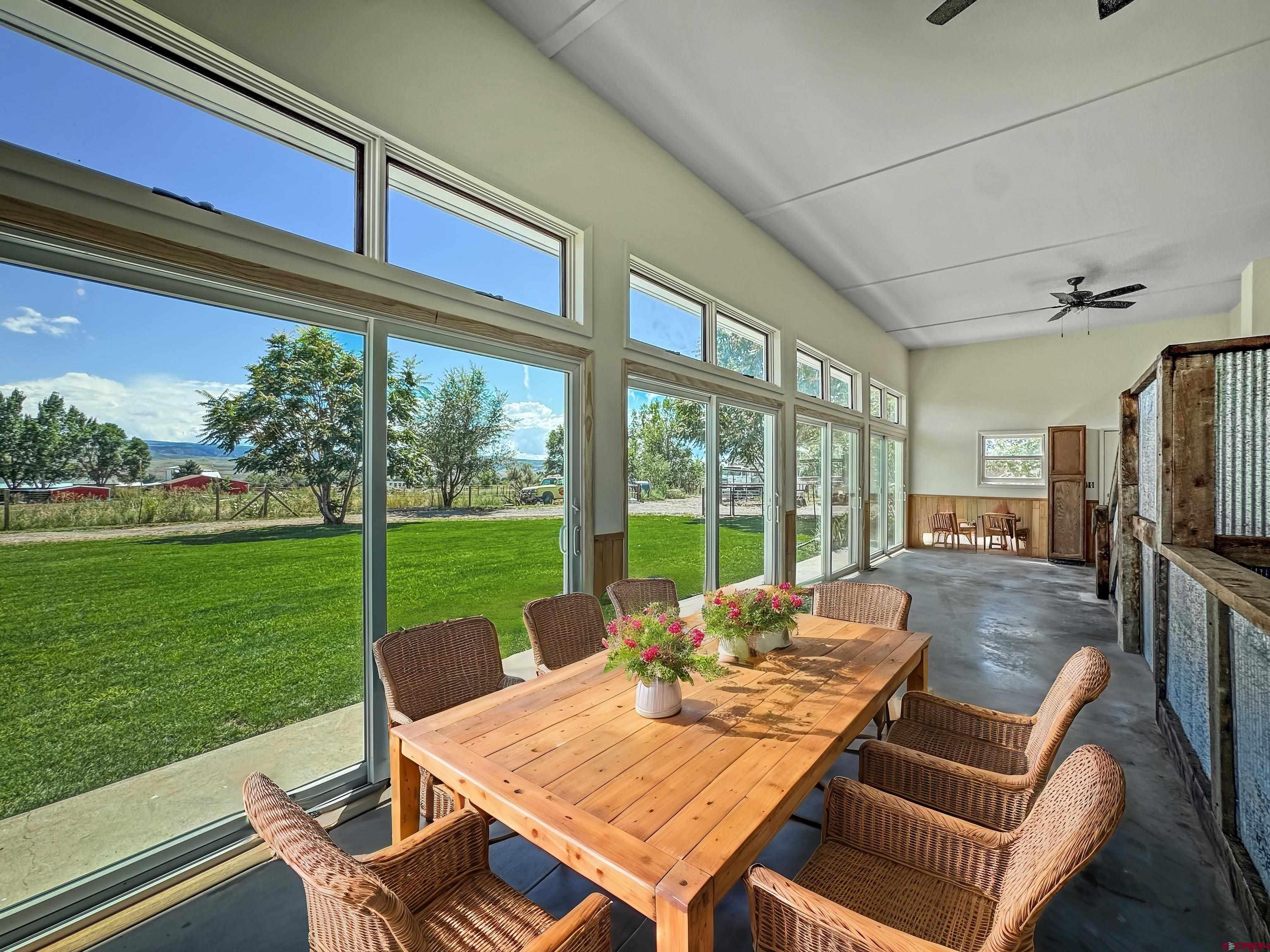 9627 3200th Road Hotchkiss, CO 81419 - Photo 16 of 44 a view of a patio with table and chairs potted plants with wooden floor and garden view