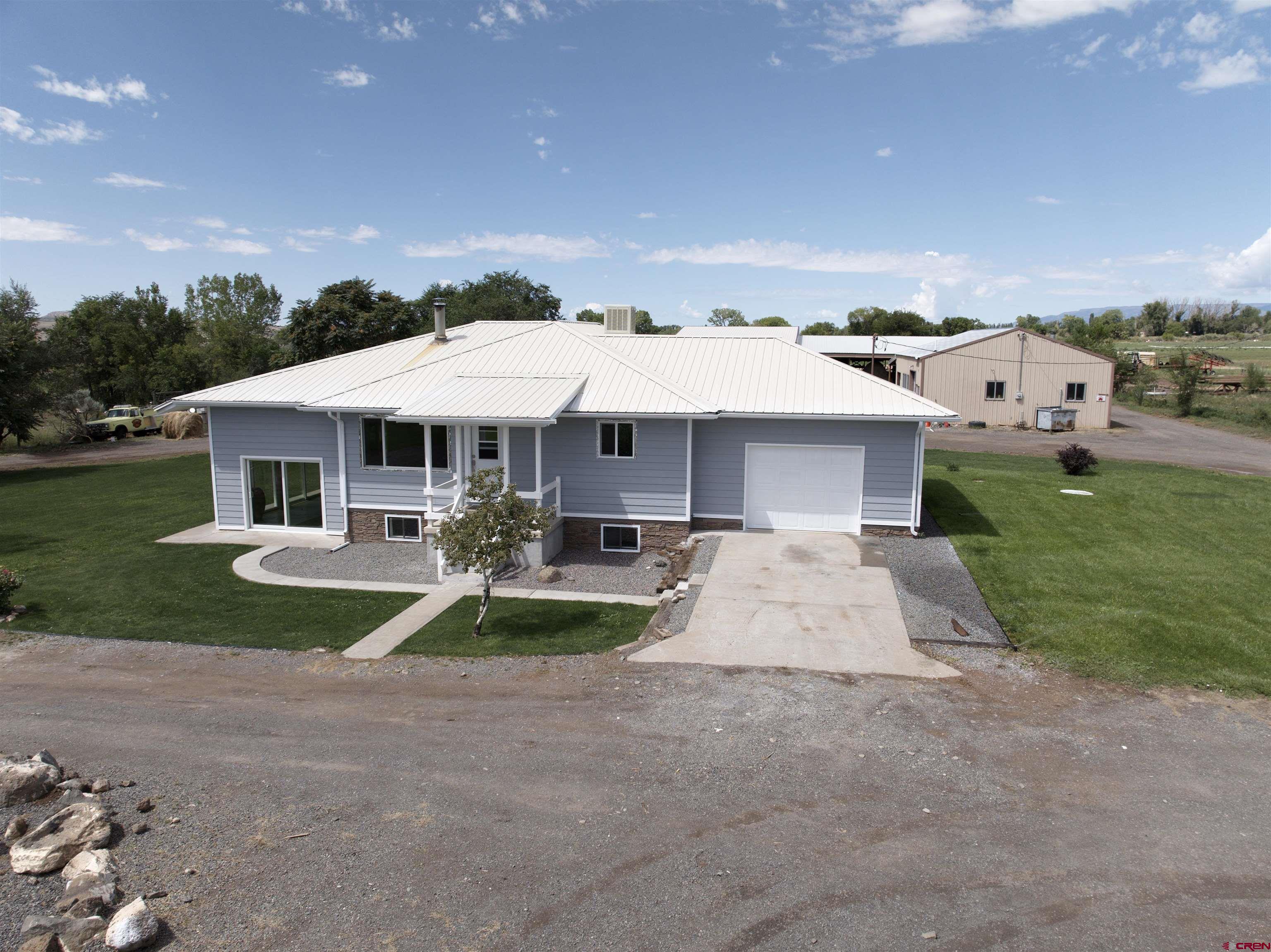 9627 3200th Road Hotchkiss, CO 81419 - Photo 4 of 44 a front view of a house with yard patio and green space