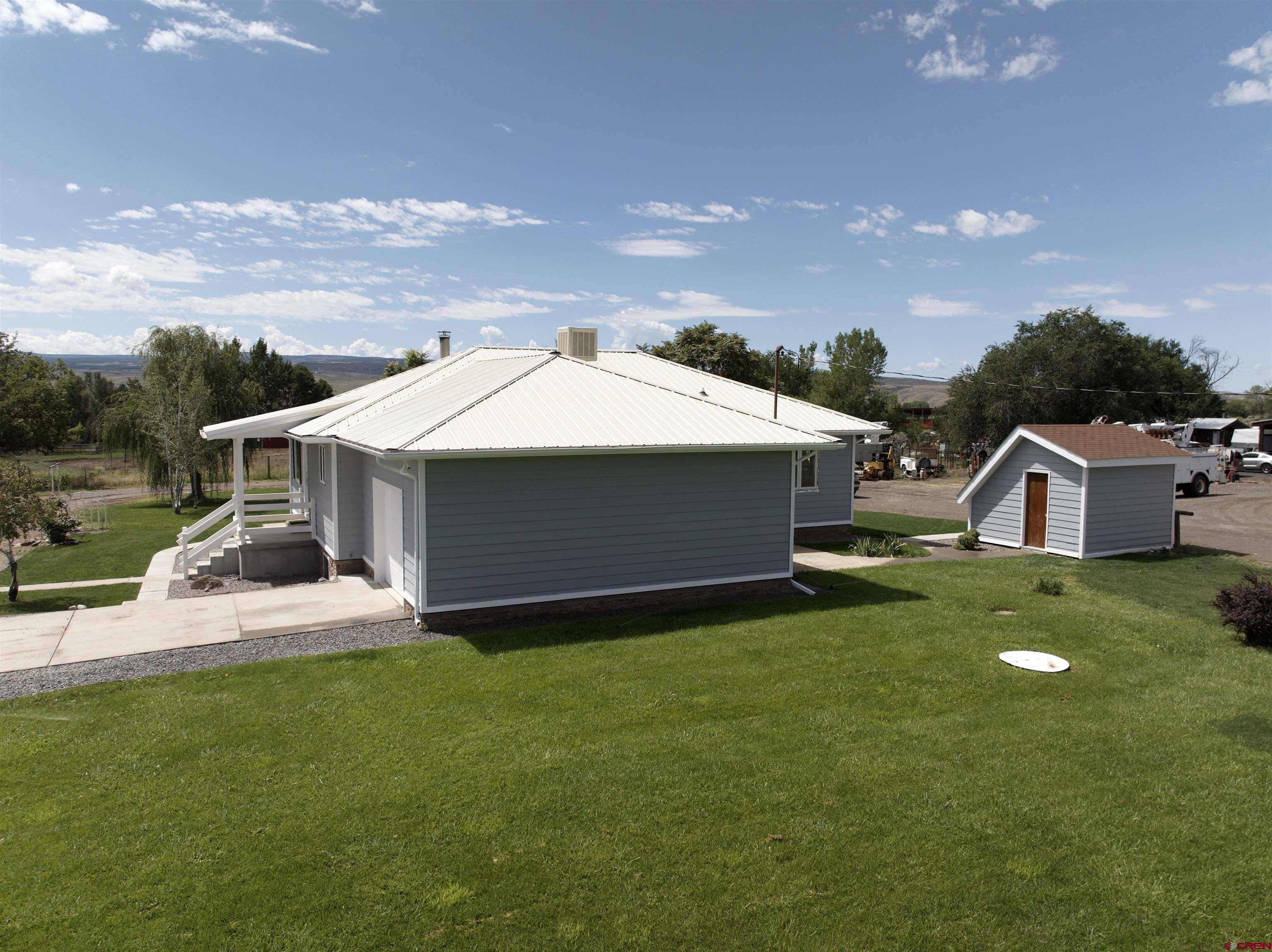 9627 3200th Road Hotchkiss, CO 81419 - Photo 9 of 44 a front view of a house with a garden and yard