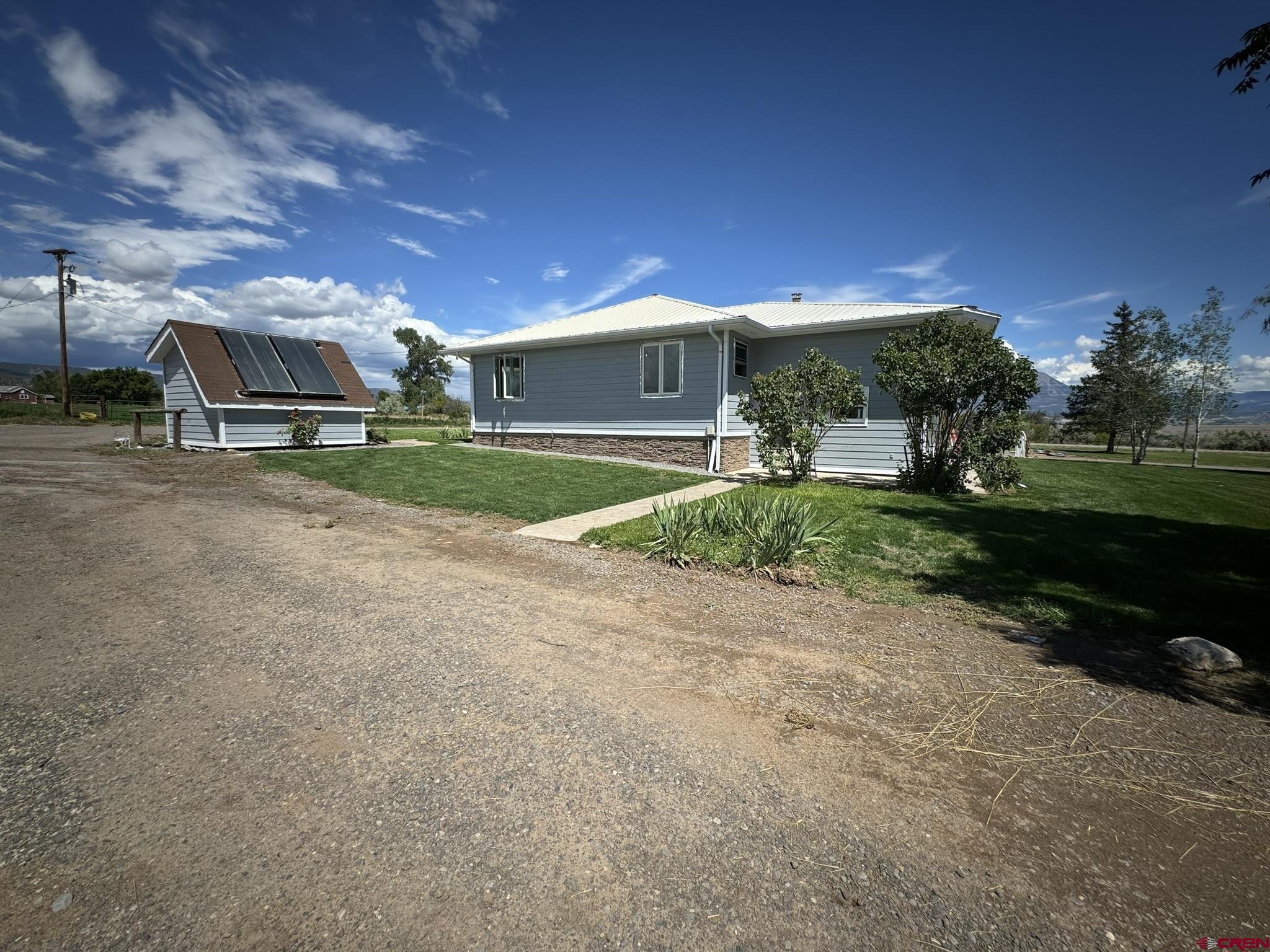 9627 3200th Road Hotchkiss, CO 81419 - Photo 9 of 44 a front view of a house with a yard and garage