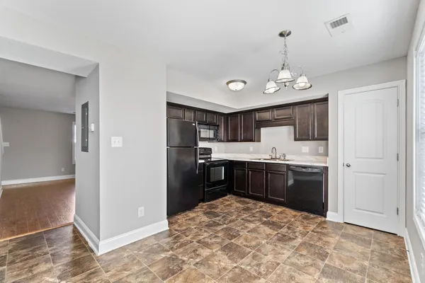 a large kitchen with kitchen island granite countertop a refrigerator and a sink