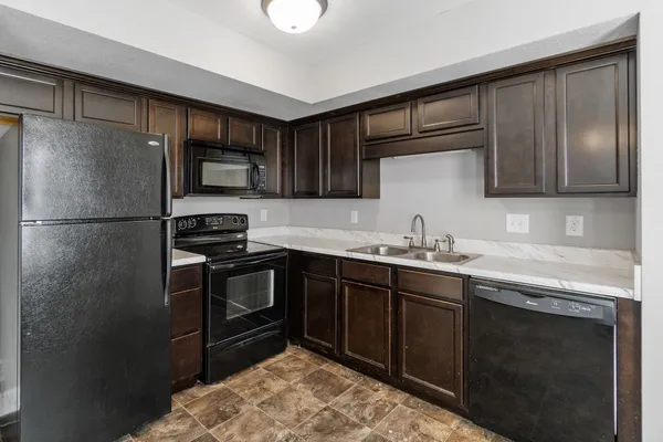 a kitchen with a sink refrigerator and cabinets