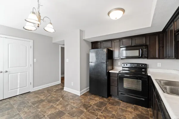 a kitchen with stainless steel appliances granite countertop a refrigerator and a stove top oven