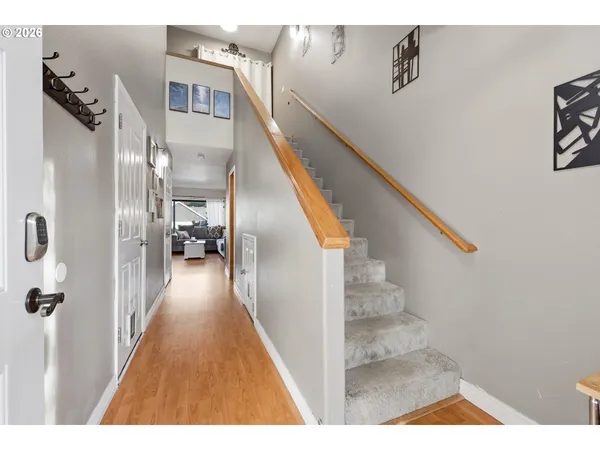 a view of a hallway with wooden floor and stairs