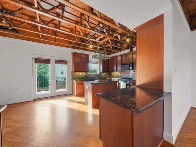 a kitchen with stainless steel appliances granite countertop a sink a stove and a wooden floors