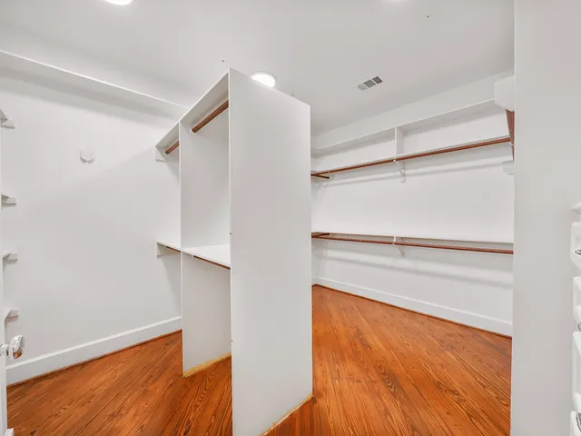 a view of walk in closet with empty racks