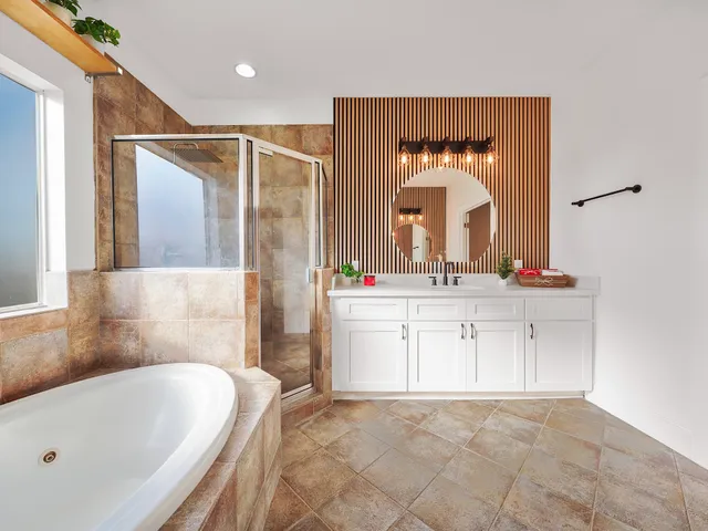 a bathroom with a tub sink and mirror