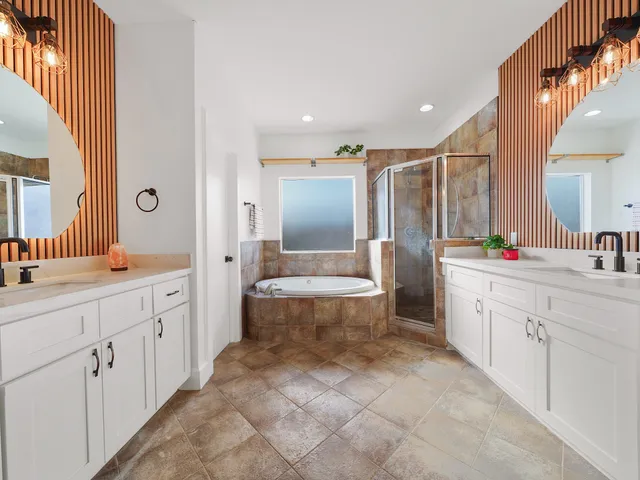 a bathroom with a double vanity sink a toilet a mirror and shower